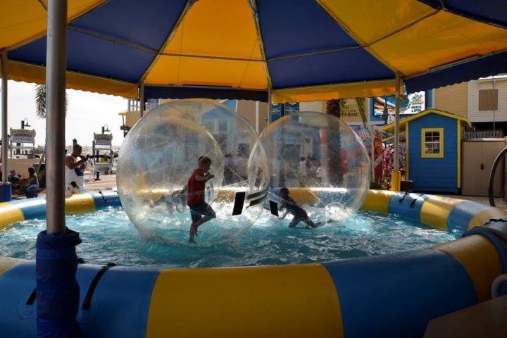a group of people sitting at a table with a blue umbrella