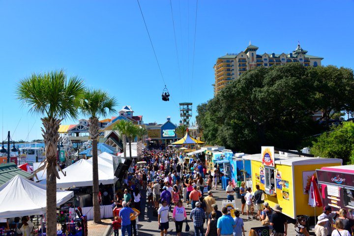 a person ziplining above a group of people walking down the street